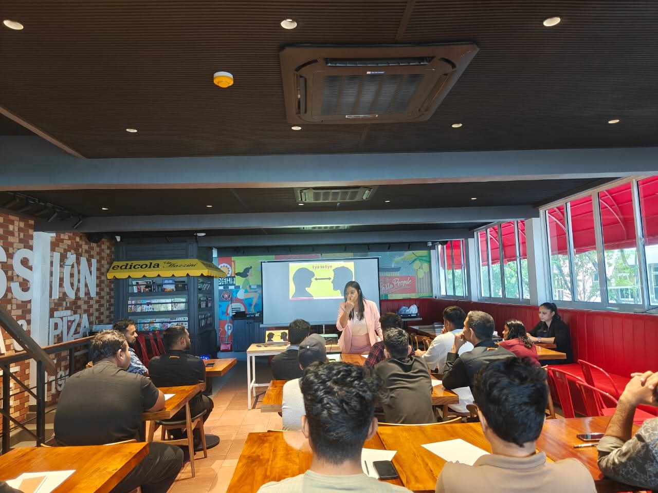Shivalatha delivering a live learning session in a restaurant environment